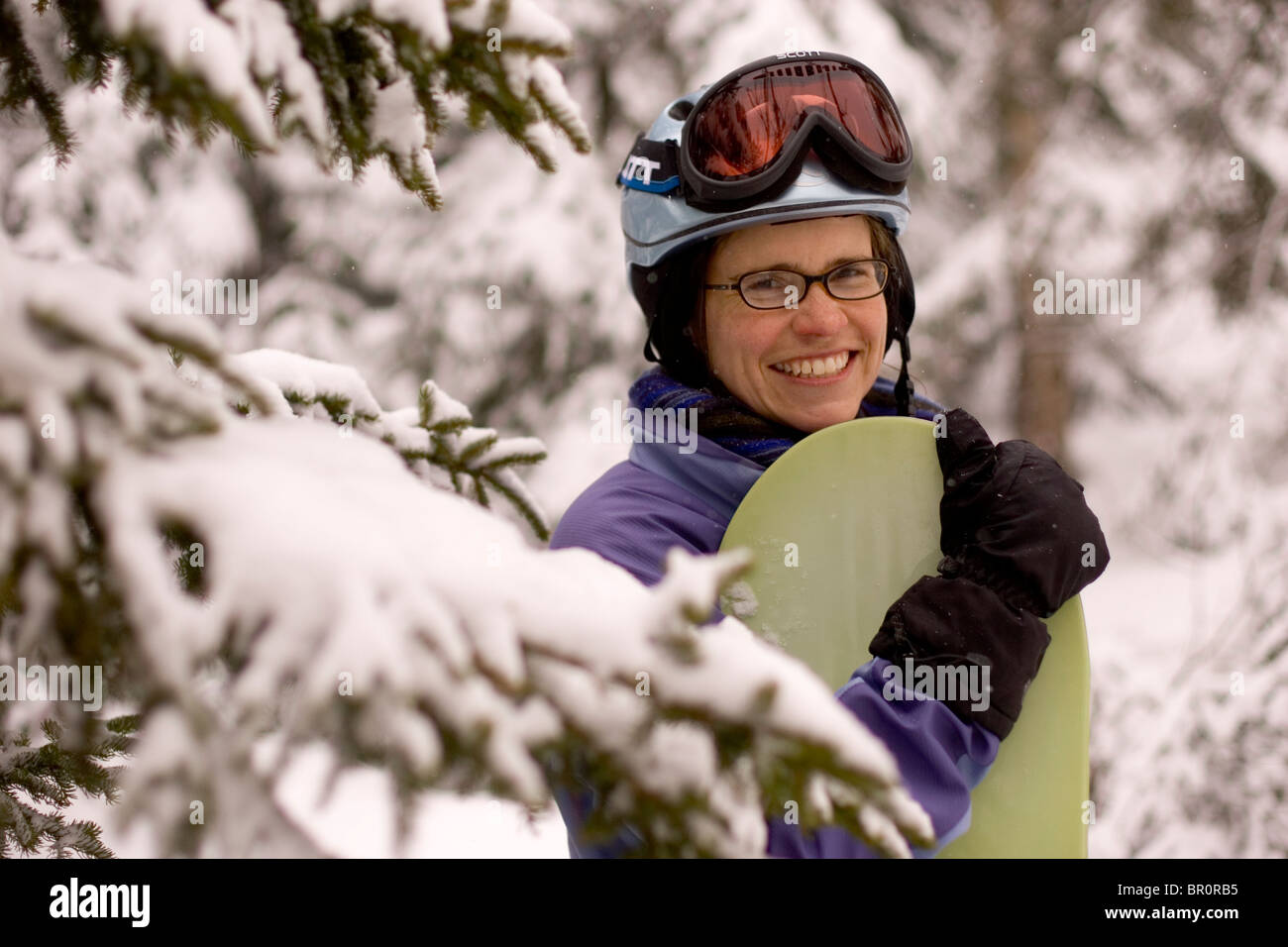A young woman smiles through the trees on vacation at Sunday River ski