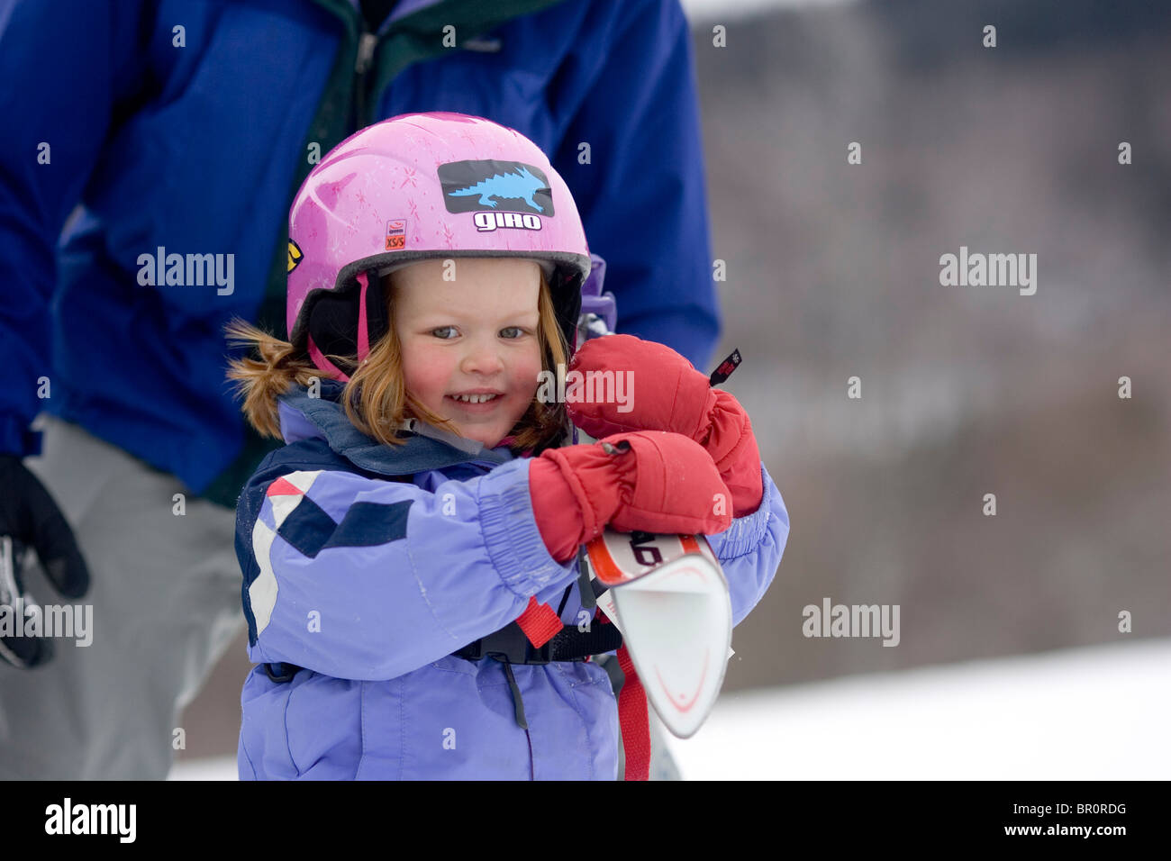 A young girl learns to ski with her father at Sunday River in Bethel, Maine. Stock Photo