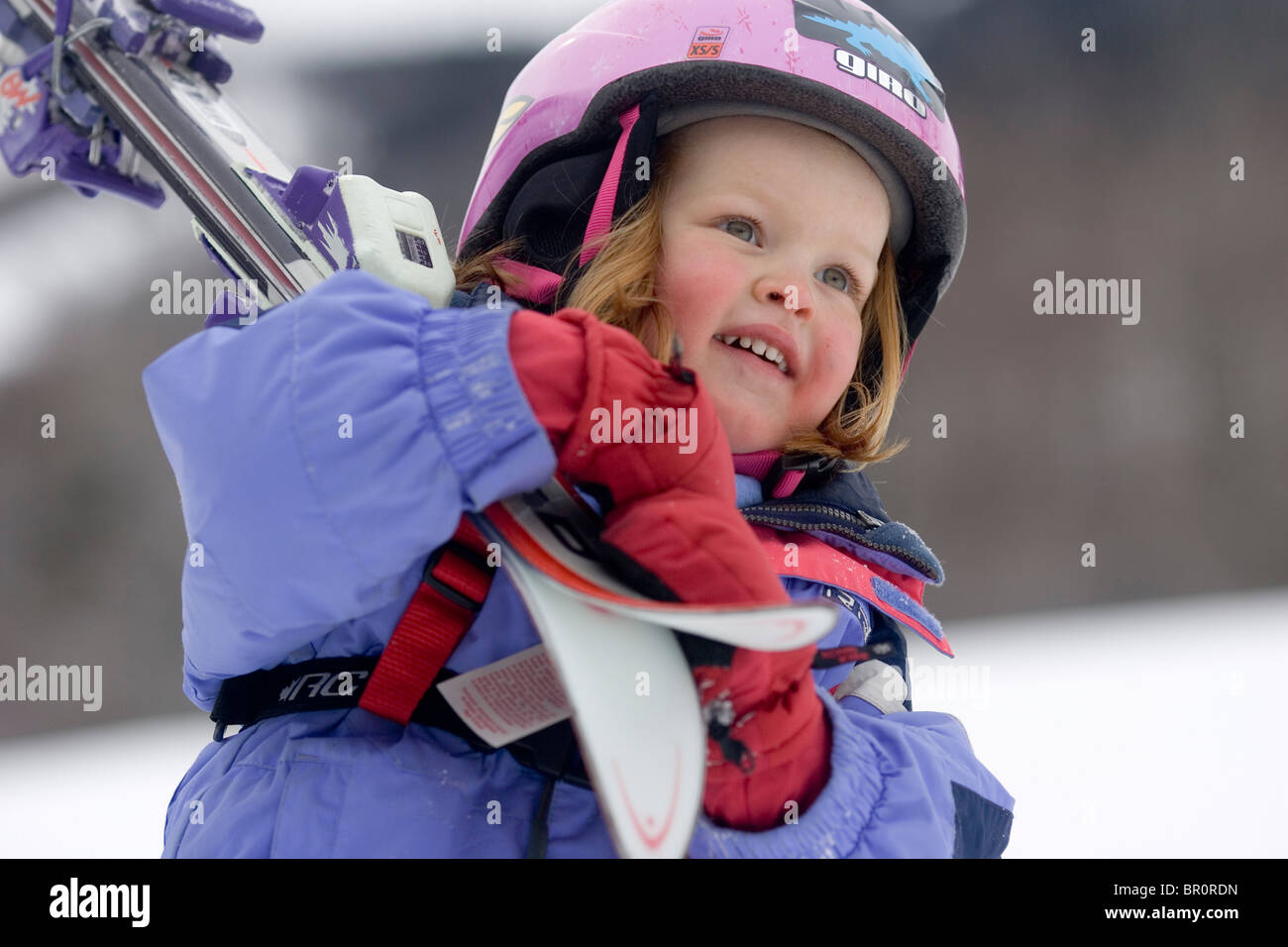 A young girl carries her skis while learinging to ski at Sunday River in Bethel, Maine. Stock Photo