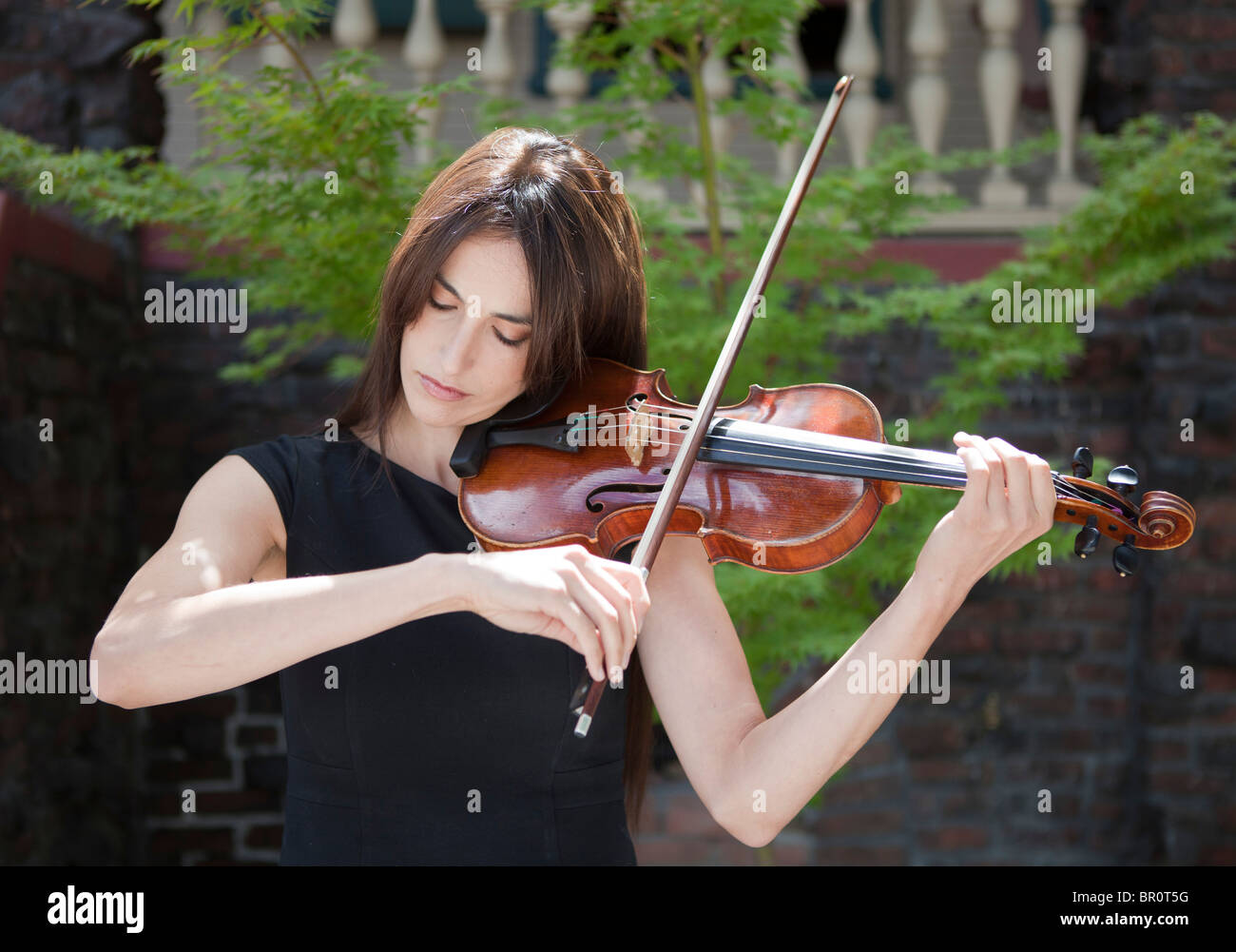 A female violinist playing outdoors, outside a building Stock Photo