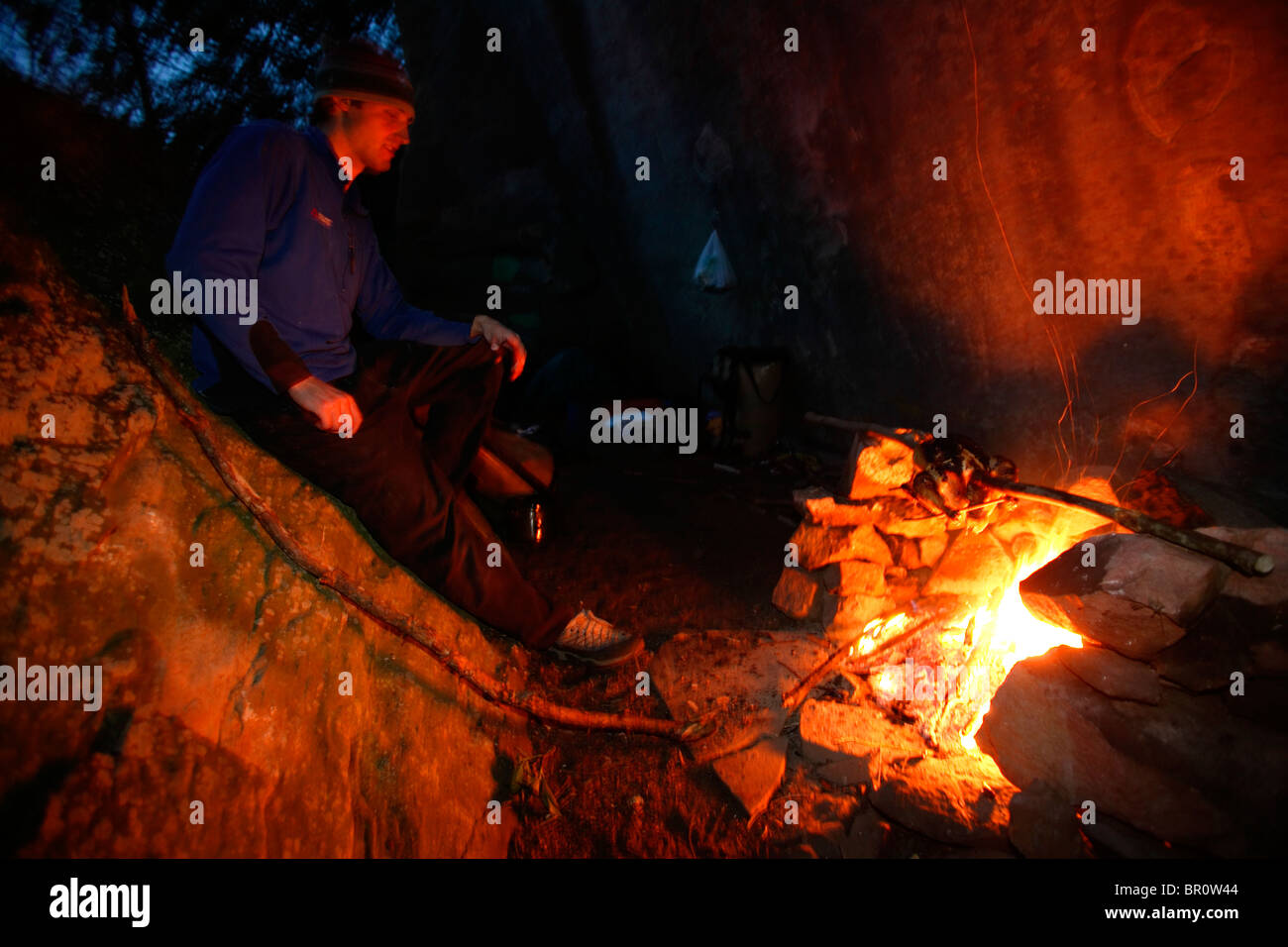 A man relaxes in front of a campfire while on a climbing trip to the Big South Fork near Oneida, TN. Stock Photo