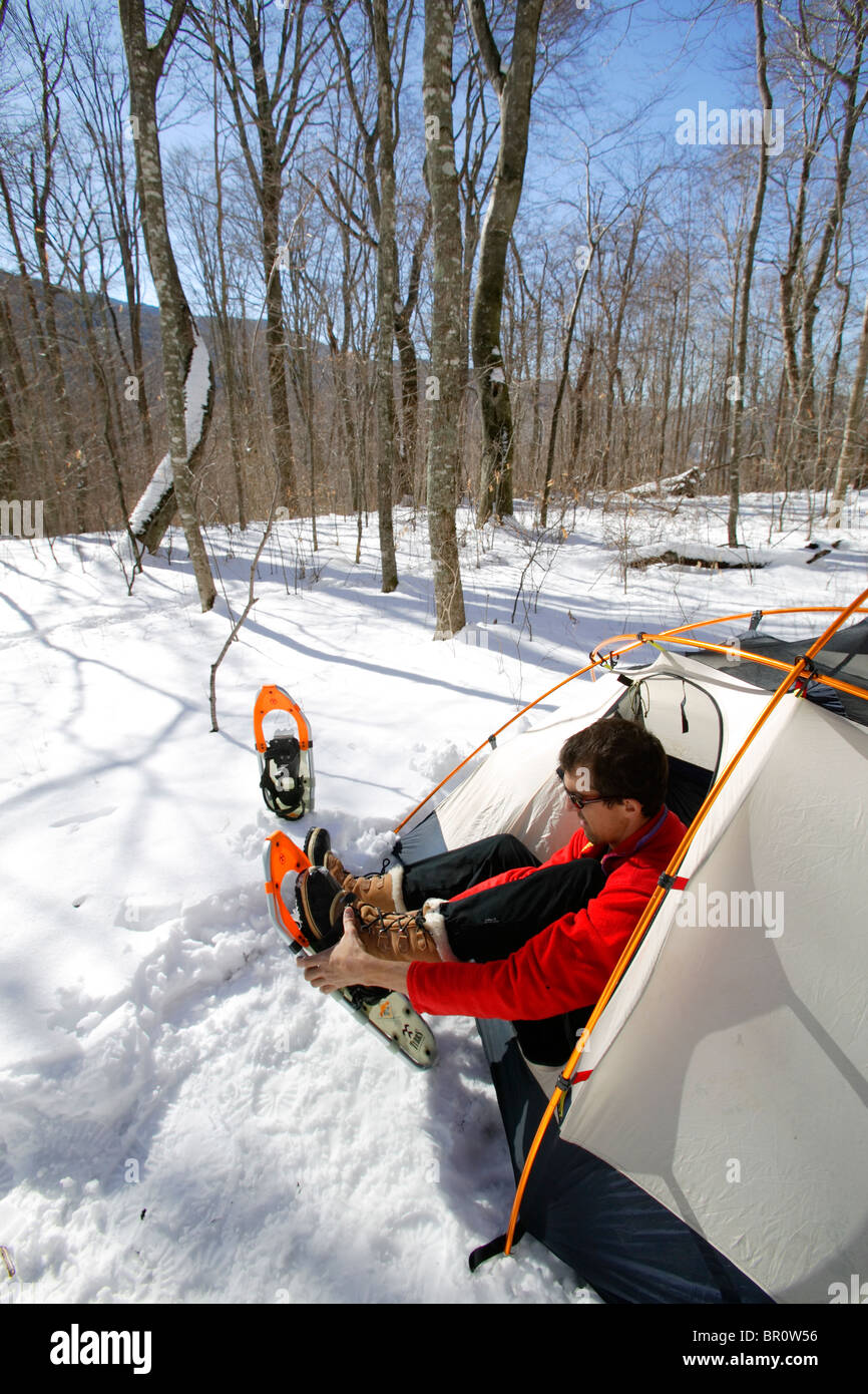 Male puts on snowshoes at camp on Roan Mountain along the Appalachian Trail on the TN/NC border. Stock Photo