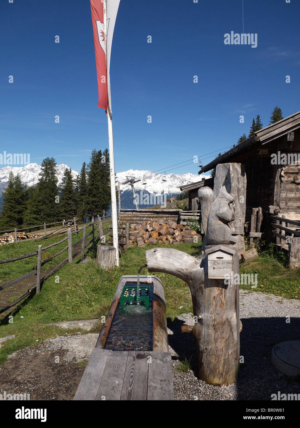 At the Hochmandalm hut in the Austrian Tirol cold mountain water cools beer in the cattle trough Stock Photo