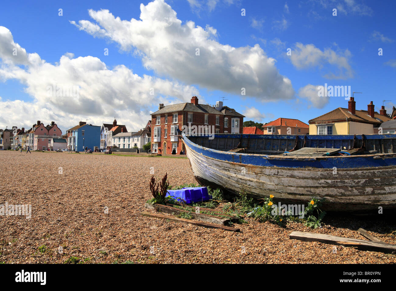 Fishing boat on Aldeburgh beach in front of the row of colourful town houses. Summers day in Suffolk East Anglia. Stock Photo