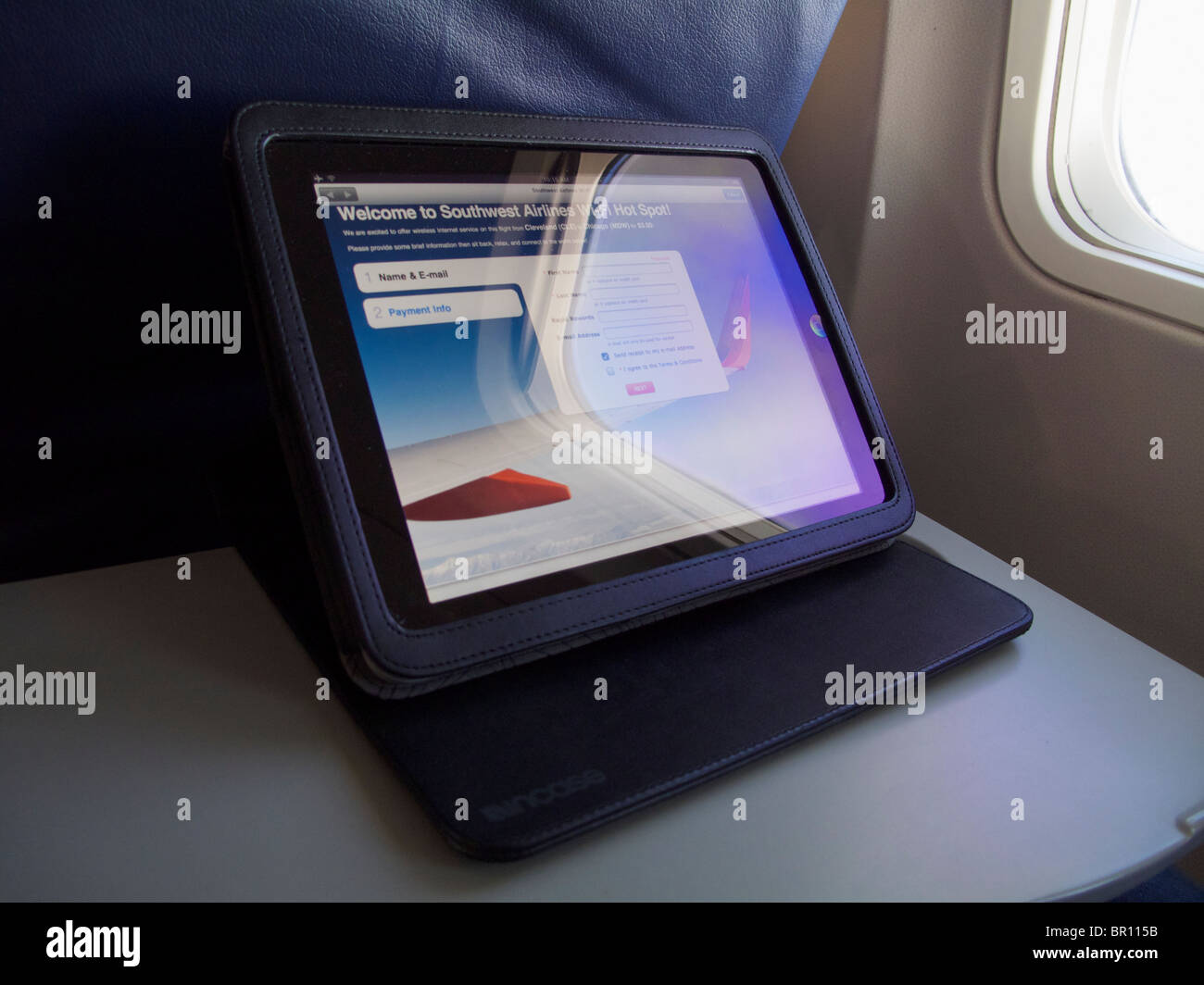 Apple iPad on airliner tray table with screen displaying wifi login