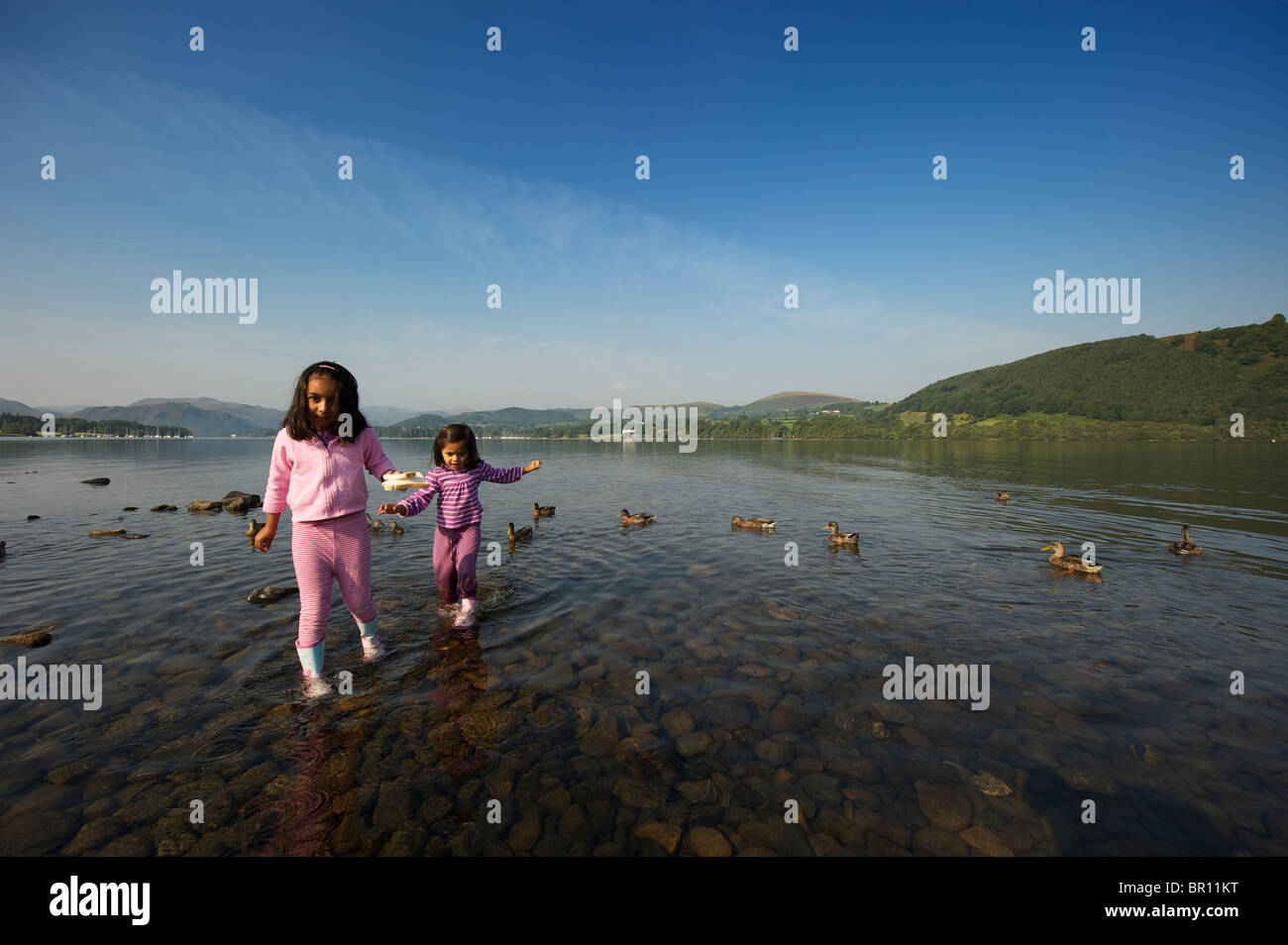 Two children playing in the water Ullswater Lake District UK Stock Photo