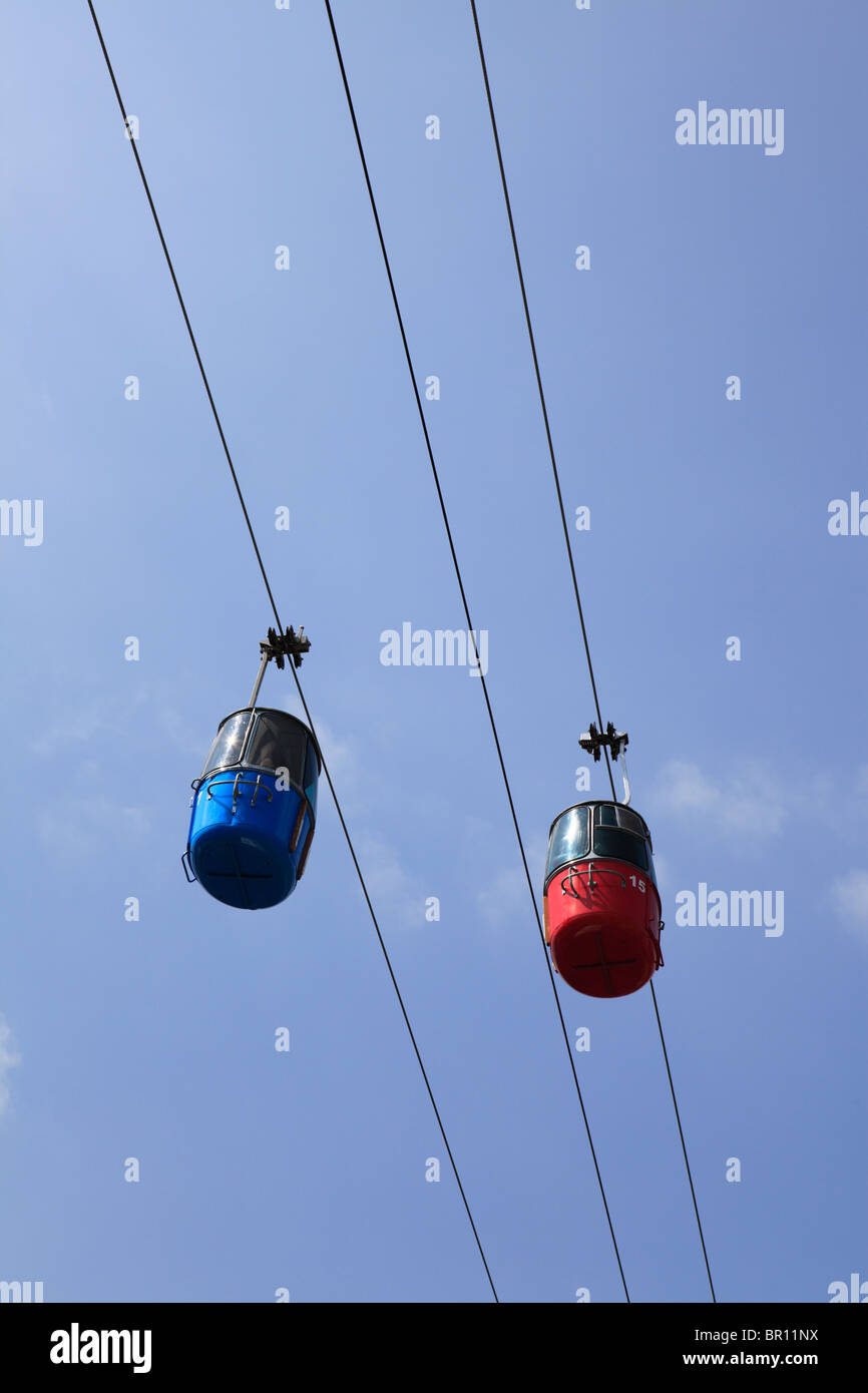 Red and blue skyride aerial lift capsules glide overhead at the 2009 Minnesota State Fair. Stock Photo