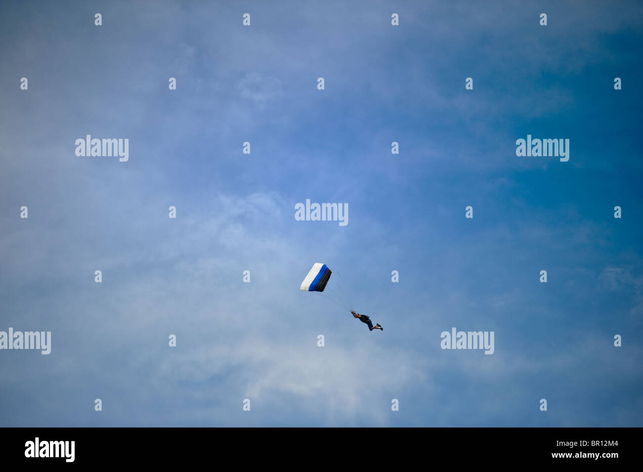 Skydiver parachutist intentionally spiral out of the sky to swoop their landing. Stock Photo