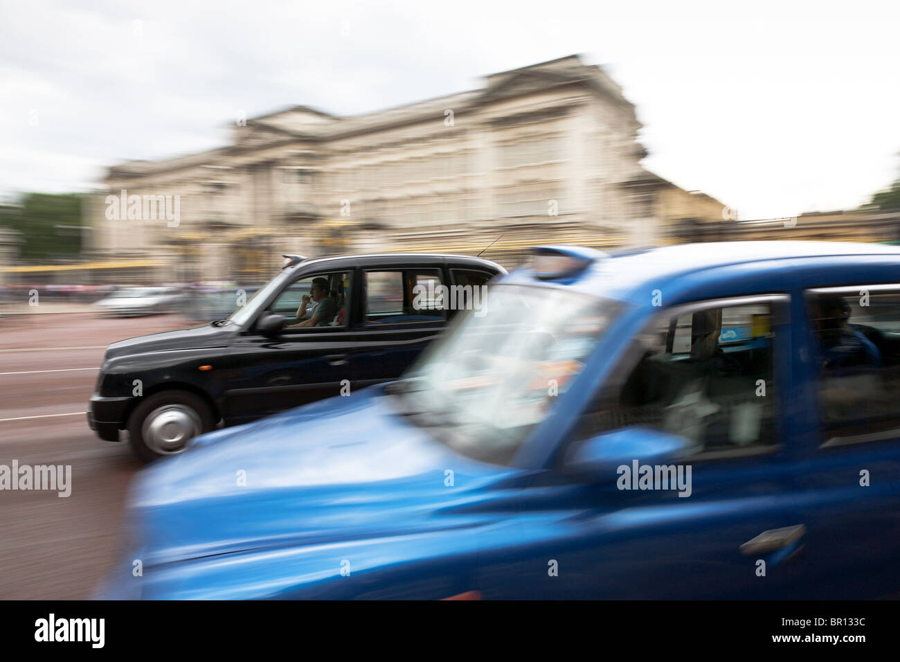 Taxis whizzing past Buckingham Palace, London Stock Photo