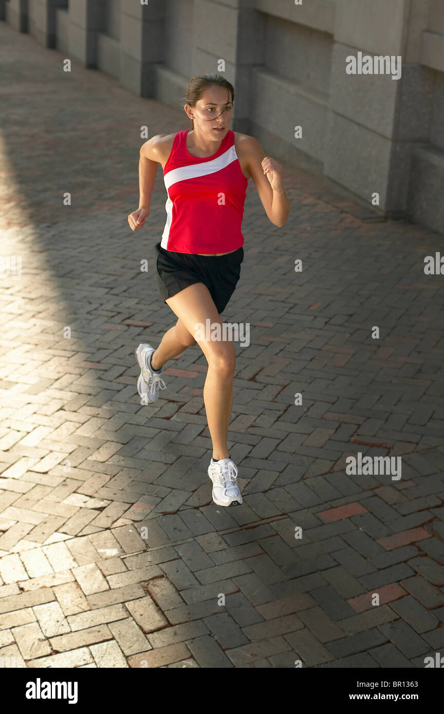 Woman jogging on sidewalk Stock Photo