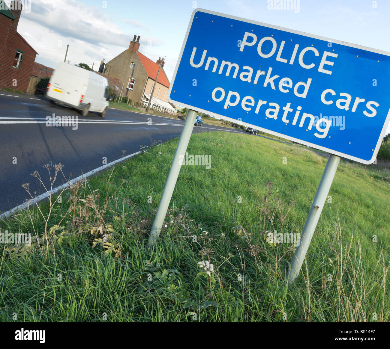 UK - unmarked police cars operating sign on a country road. White van passing. Stock Photo