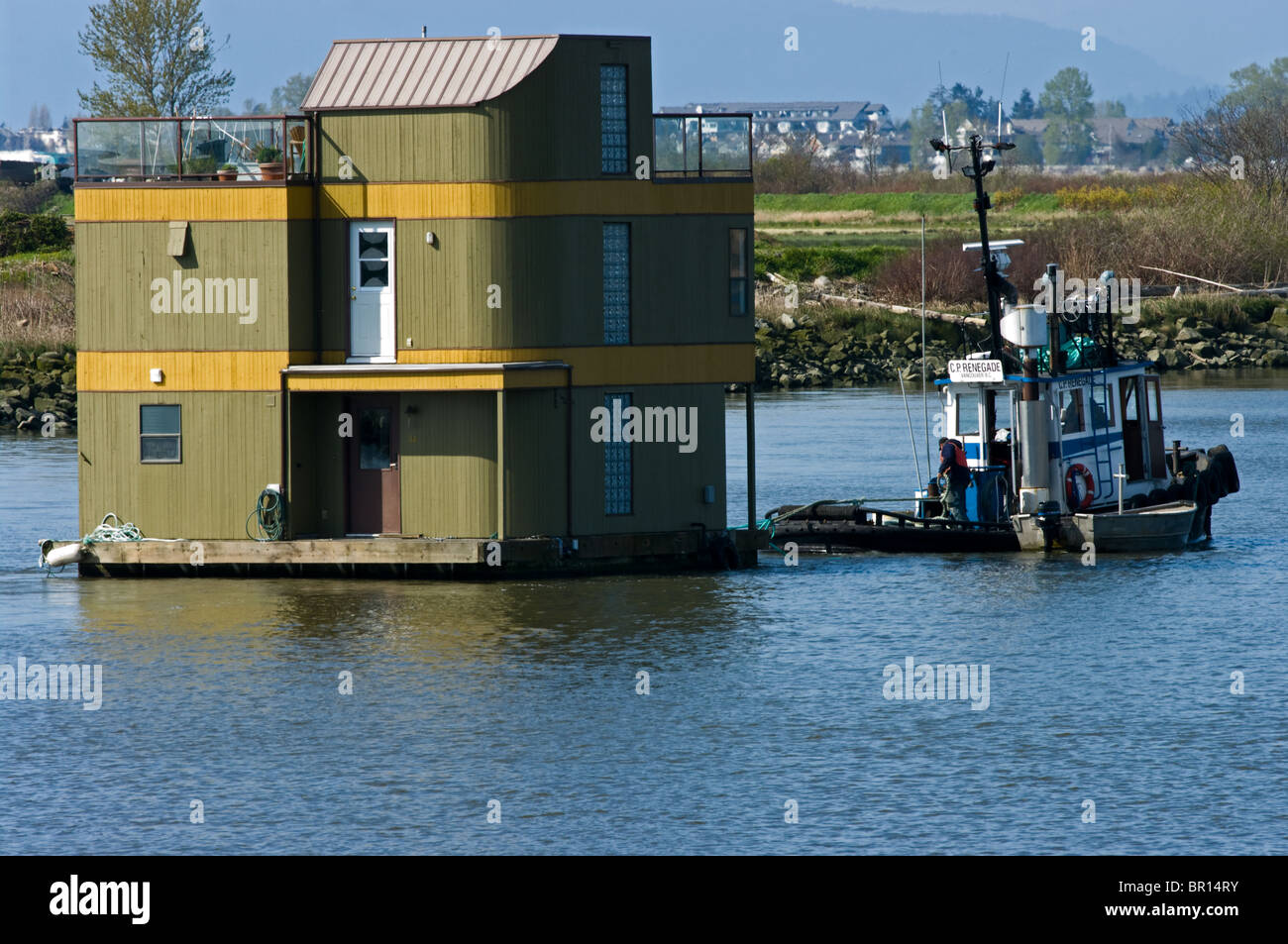 Tugboat towing a houseboat on the Fraser River Stock Photo