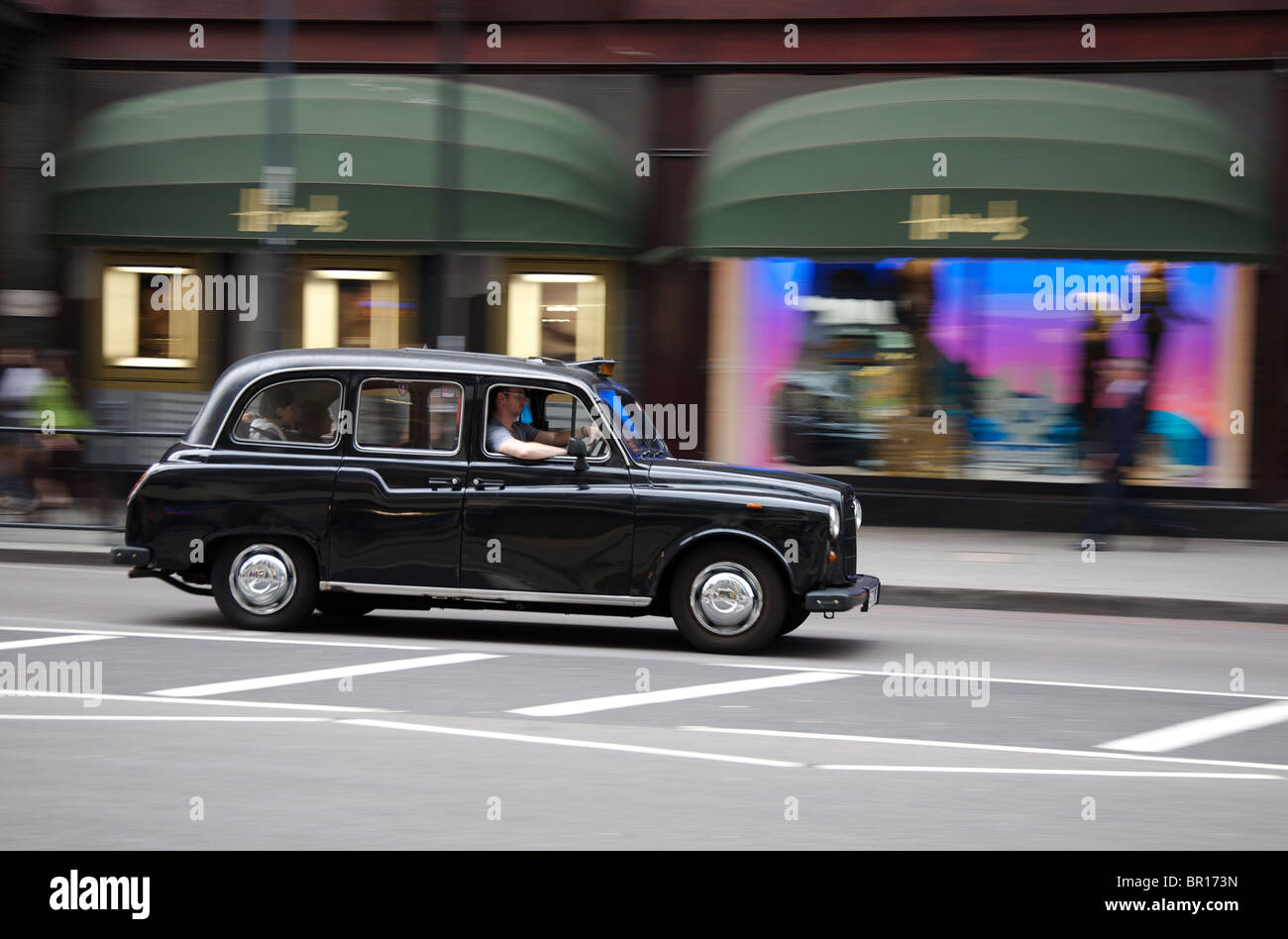 Old london taxi passing Harrods Department Store, Knightsbridge, London Stock Photo