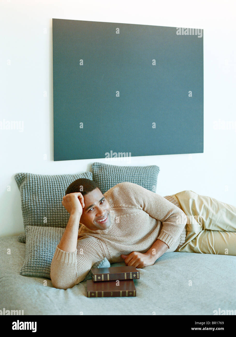 Man laying on bed with books Stock Photo Alamy
