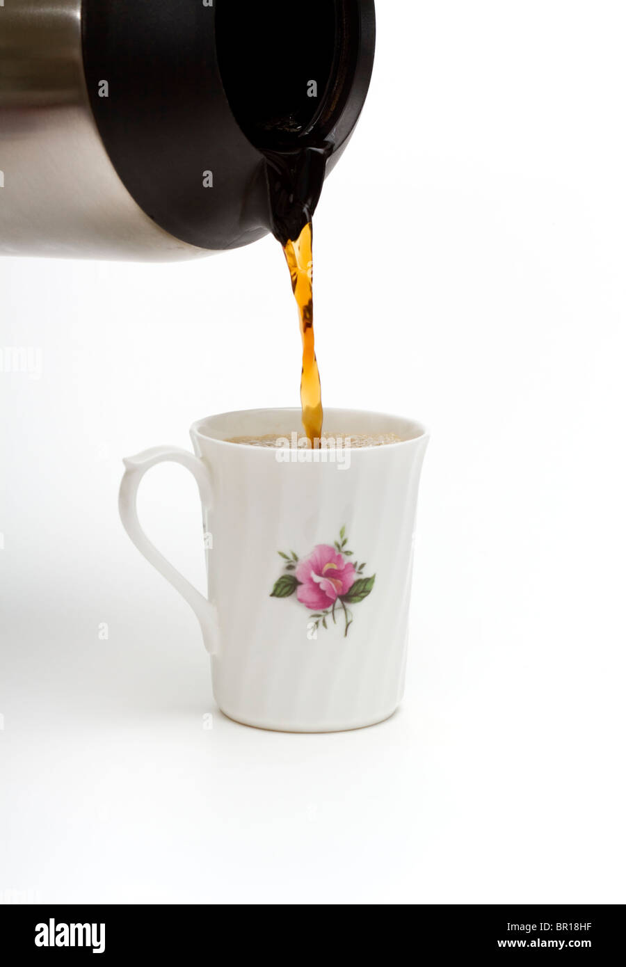 Pouring hot coffee into a china mug from a thermal carafe Stock Photo