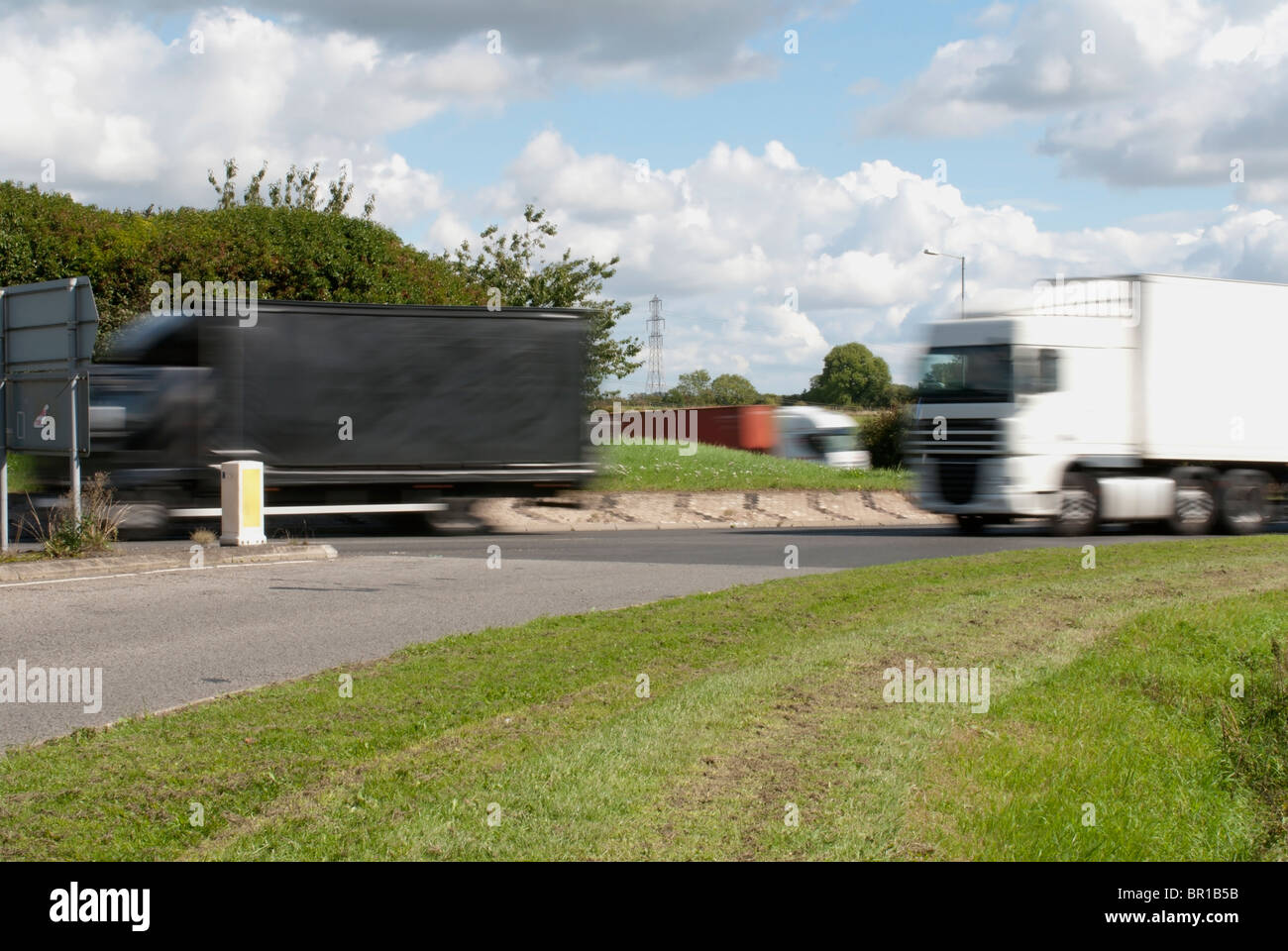 Three Lorries Travelling on a Roundabout Stock Photo