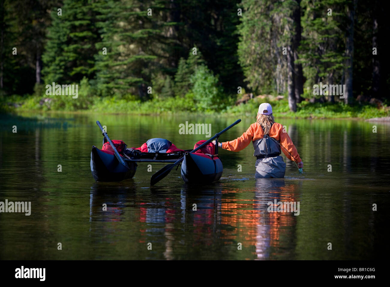 A fisherwoman wades with her pontoon boat in the Cascade mts. of Washington State. Stock Photo