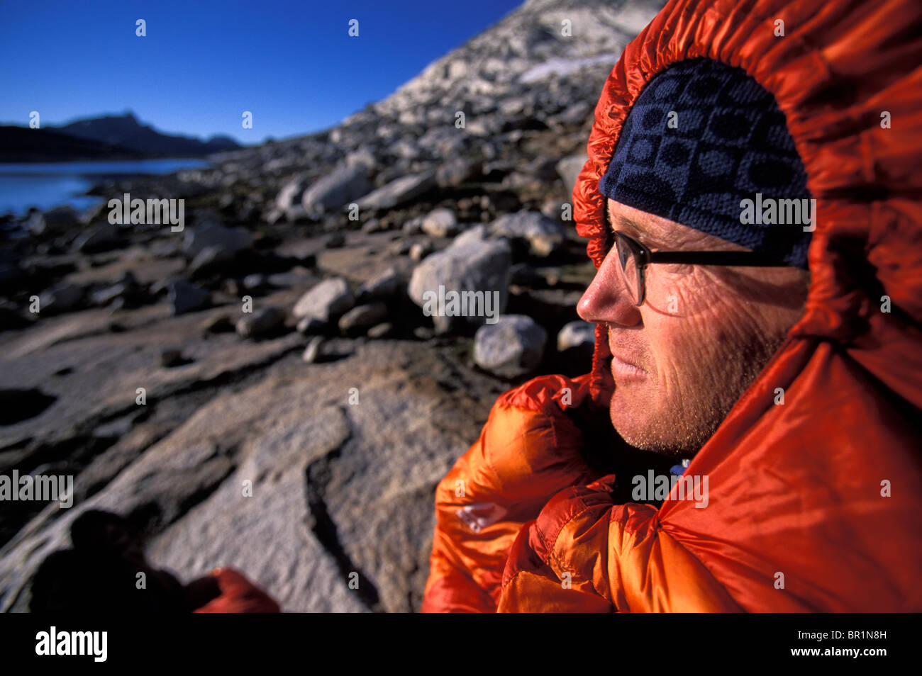 Backpacker enjoying the morning in his sleeping bag and looking out ...