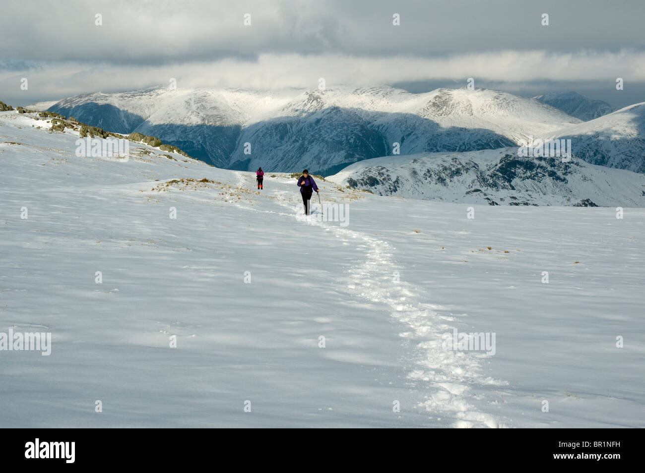 Hill walkers in snow on High Raise in winter, near Grasmere, Lake District, Cumbria, England, UK Stock Photo