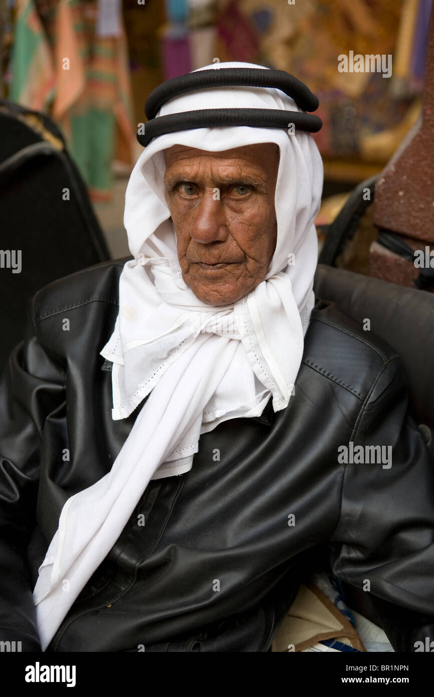 Portrait of adult Arab seller in a outdoor market wearing a leather jacket and Saudi white Ghutraon in Dubai. Stock Photo
