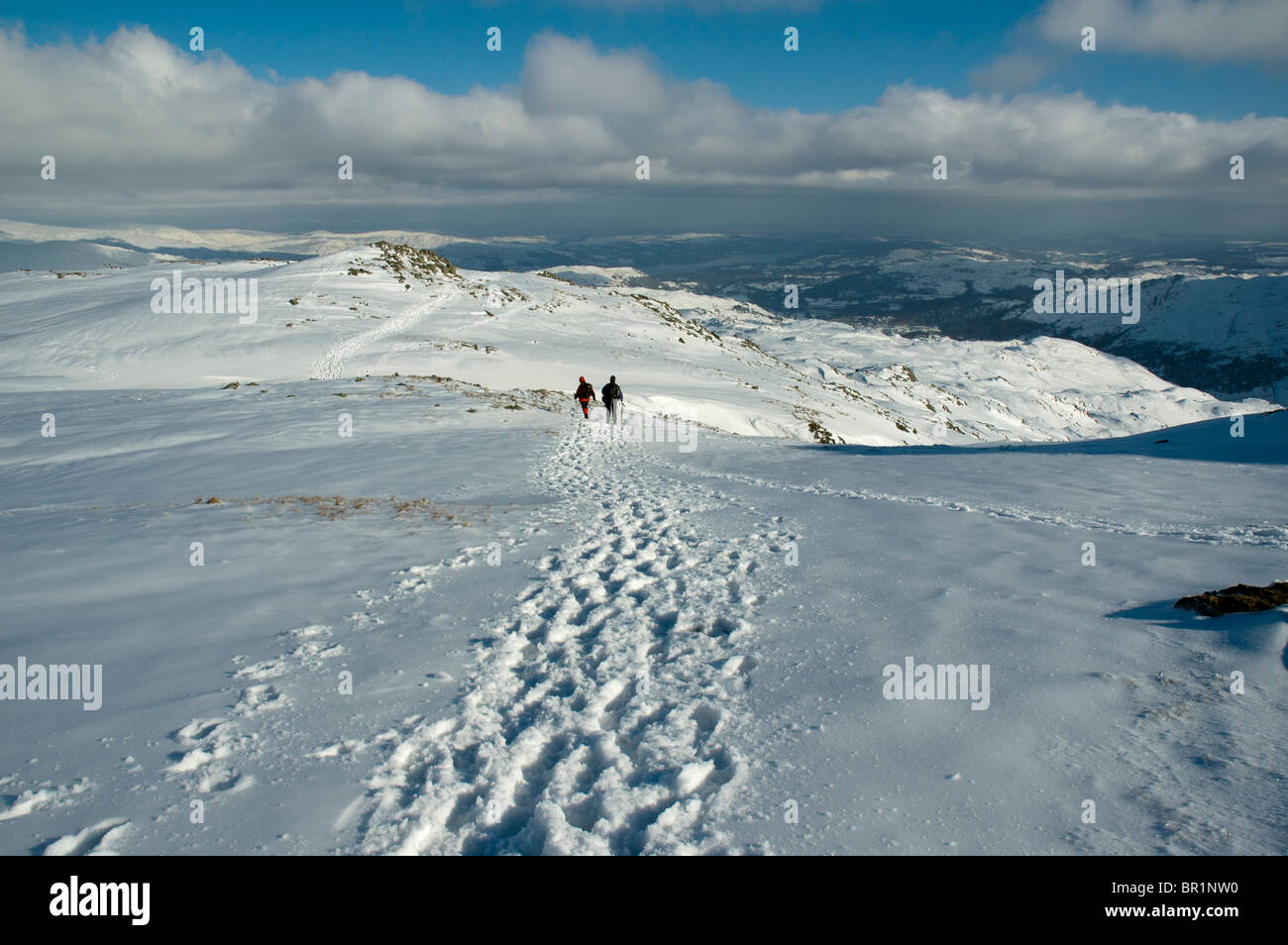 Hill walkers in snow on the High Raise plateau in winter, near Grasmere, Lake District, Cumbria, England, UK Stock Photo