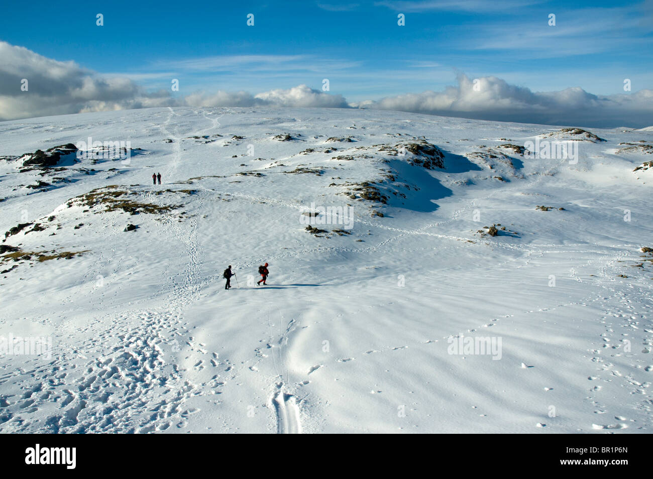 Hill walkers in snow on the High Raise plateau in winter, near Grasmere, Lake District, Cumbria, England, UK Stock Photo