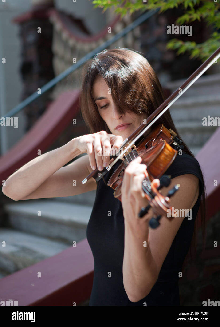 A female violinist playing outdoors, outside a building Stock Photo
