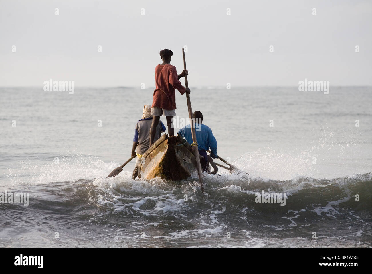 Fishermen in a boat getting into the ocean in Ghana Stock Photo