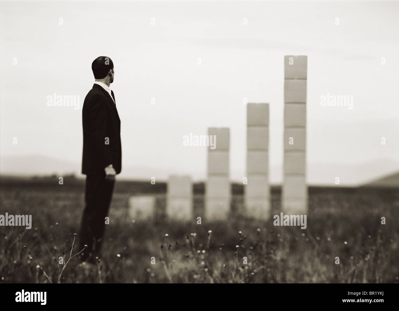 Man out on field with stacked up boxes forming a graph. Stock Photo