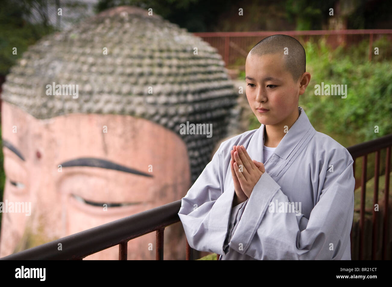 Young Buddhist nun prays above the Dafo or Great Buddha, Le Shan, Sichuan Province, China Stock Photo