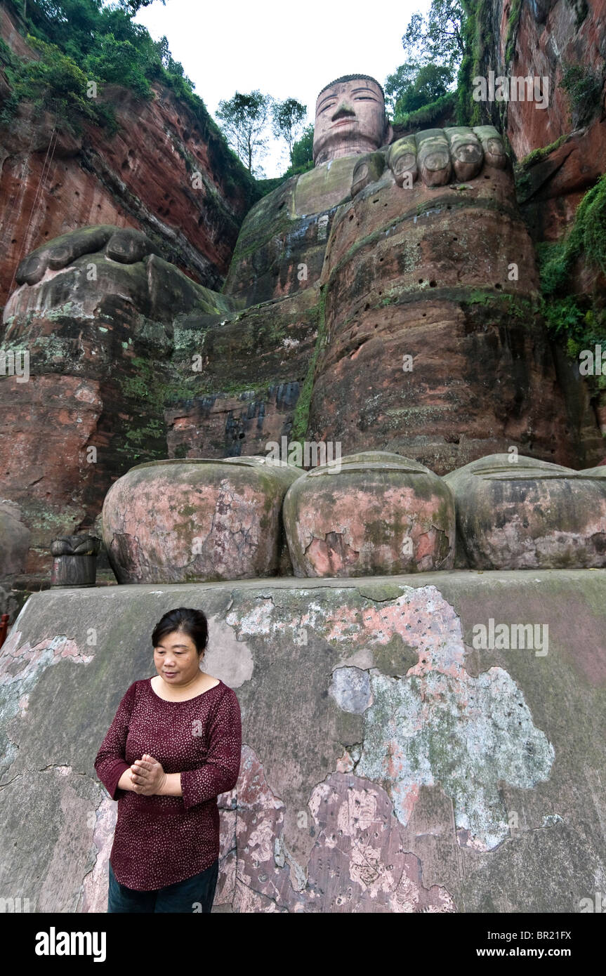 Woman prays in front of giant toes of the Dafo or Great Buddha, Le Shan, Sichuan Province, China Stock Photo