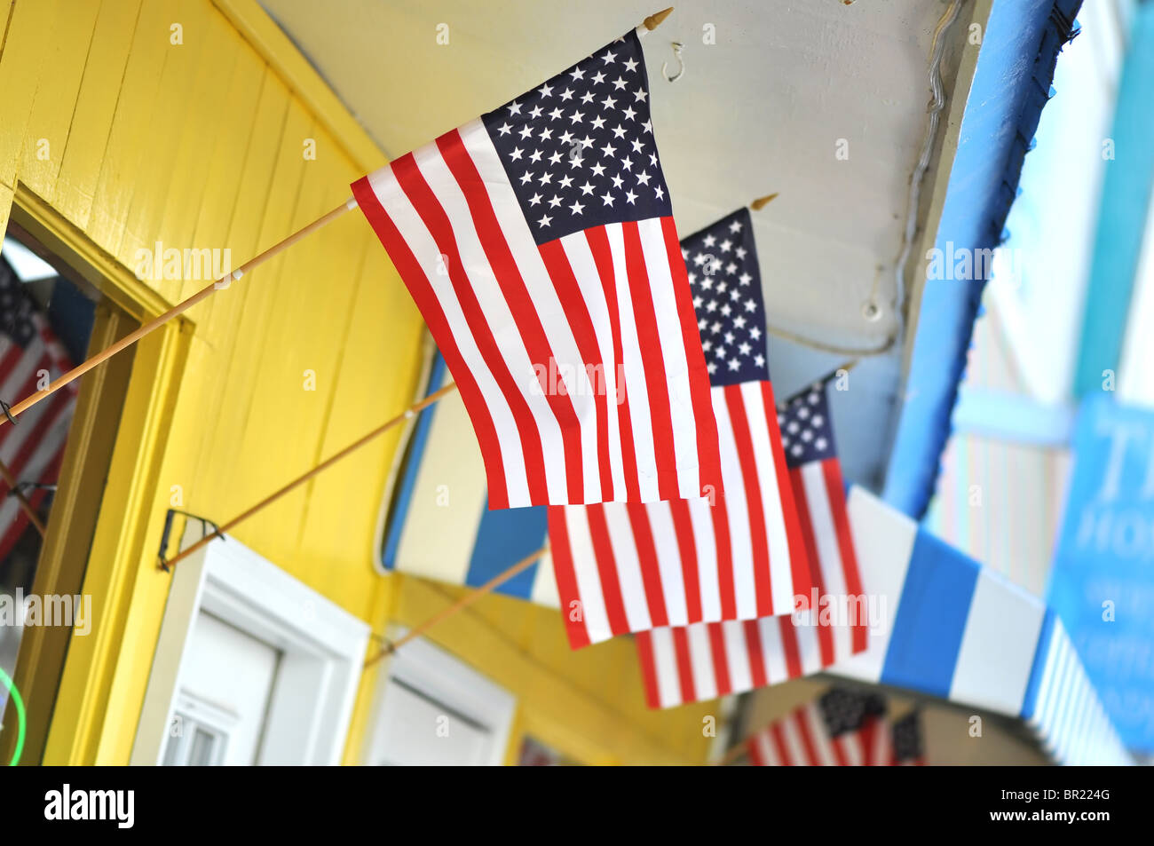 Colorful store front with three American flags flying. Stock Photo
