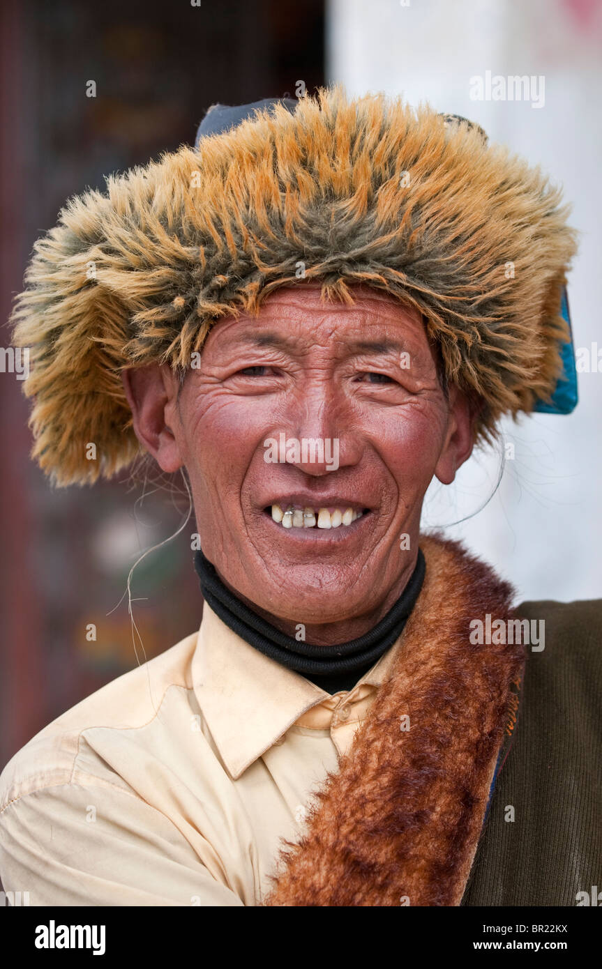 Ethnic Tibetan in fur lined cap and robe, Tagong Monastery, Sichuan Province, China Stock Photo