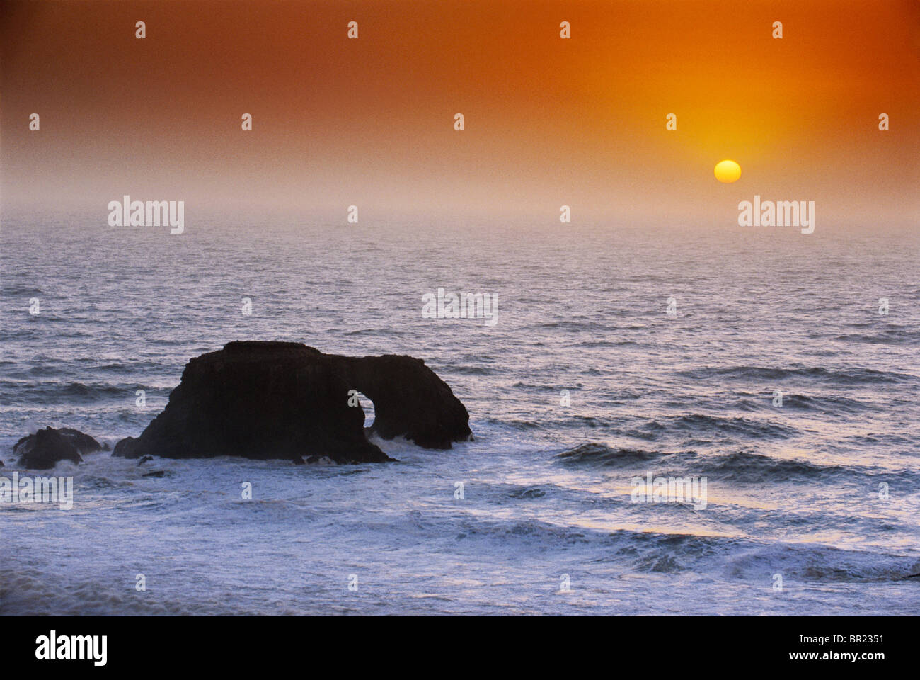 Arched Rock and Ocean Sunset Stock Photo