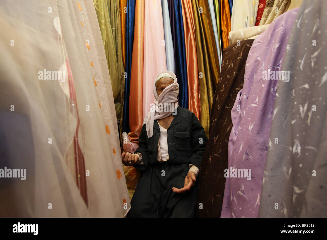 A shopkeeper in a textile shop in Qaysari bazaar in the city of Erbil ...
