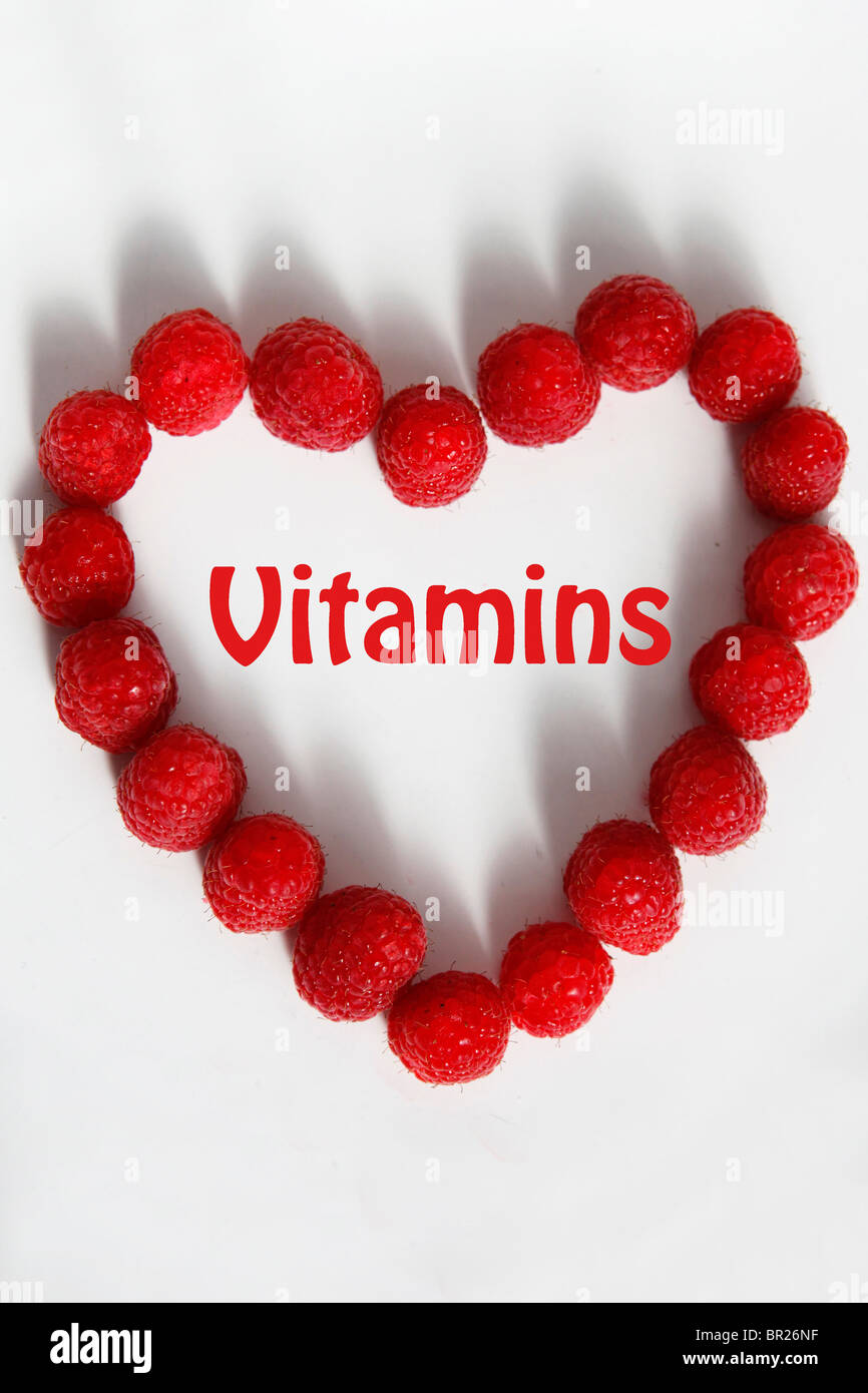 A heart shaped by raspberries with the added text "vitamins". Stock Photo