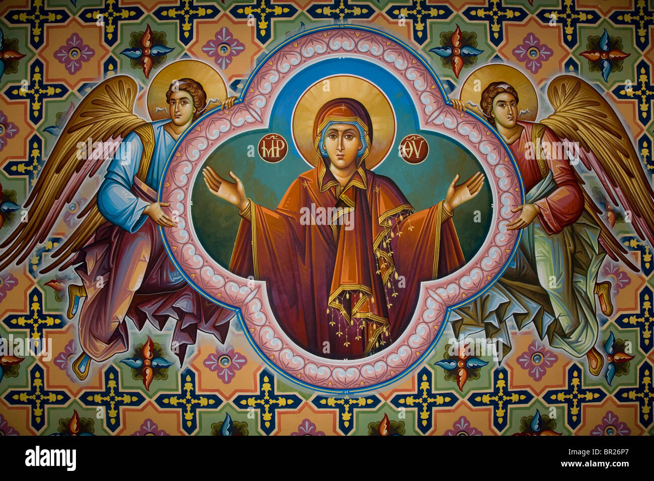 Virgin Mother Mary open arms fresco Greek Church wall two angels supporting frame colourful decoration Christianity old church Stock Photo