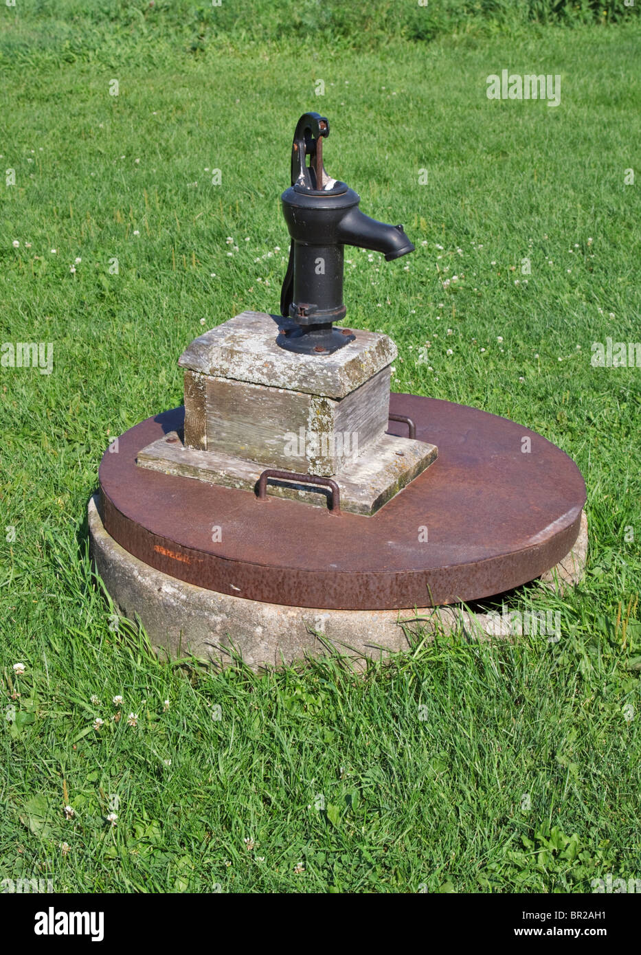 Water well with small iron hand pump at a farm in Prince Edward County, Ontario, Canada Stock Photo