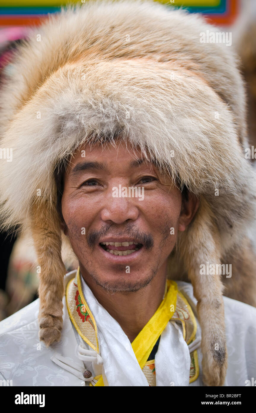 Ethnic Tibetan male dancers wear animal fur hats wait to perform at
