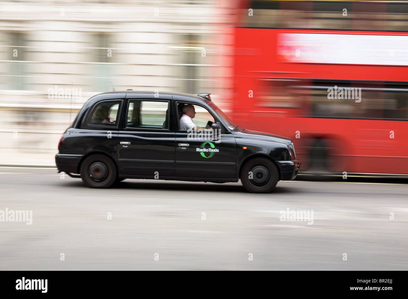 London taxi passing a bus Stock Photo