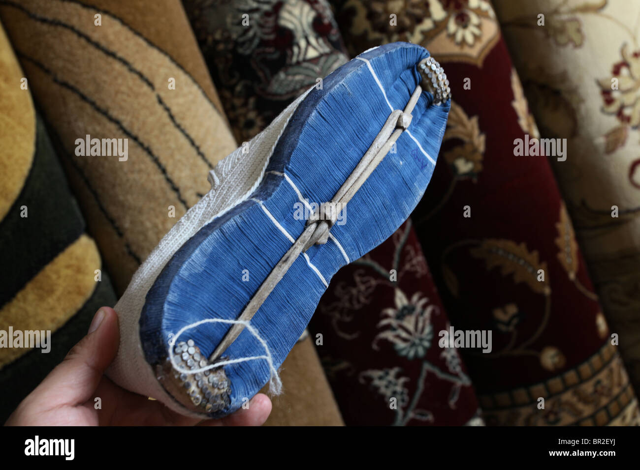 Man holds a traditional ‘Klash’ hand made cotton wool shoe made in