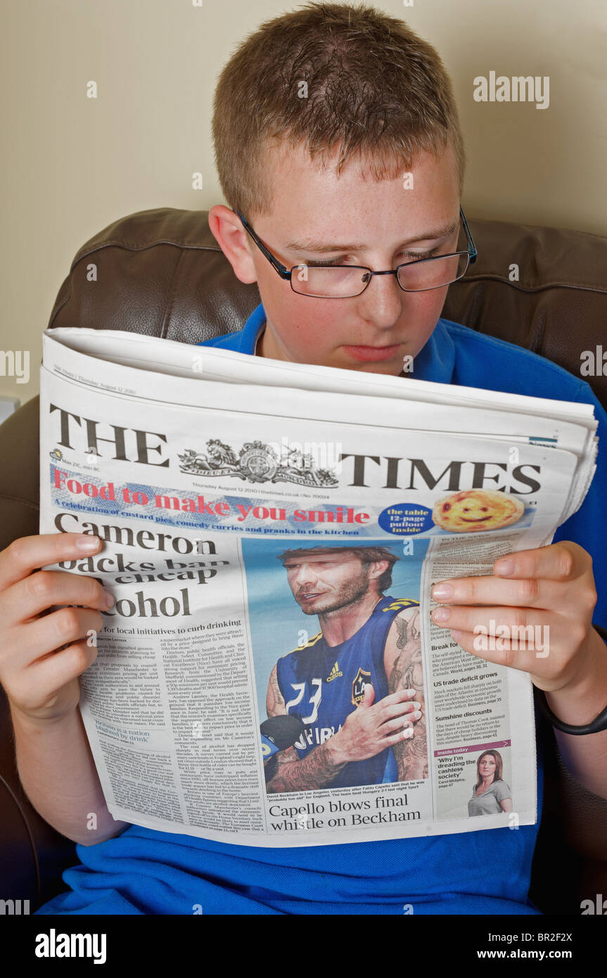 Teenage boy reading The Times newspaper Stock Photo