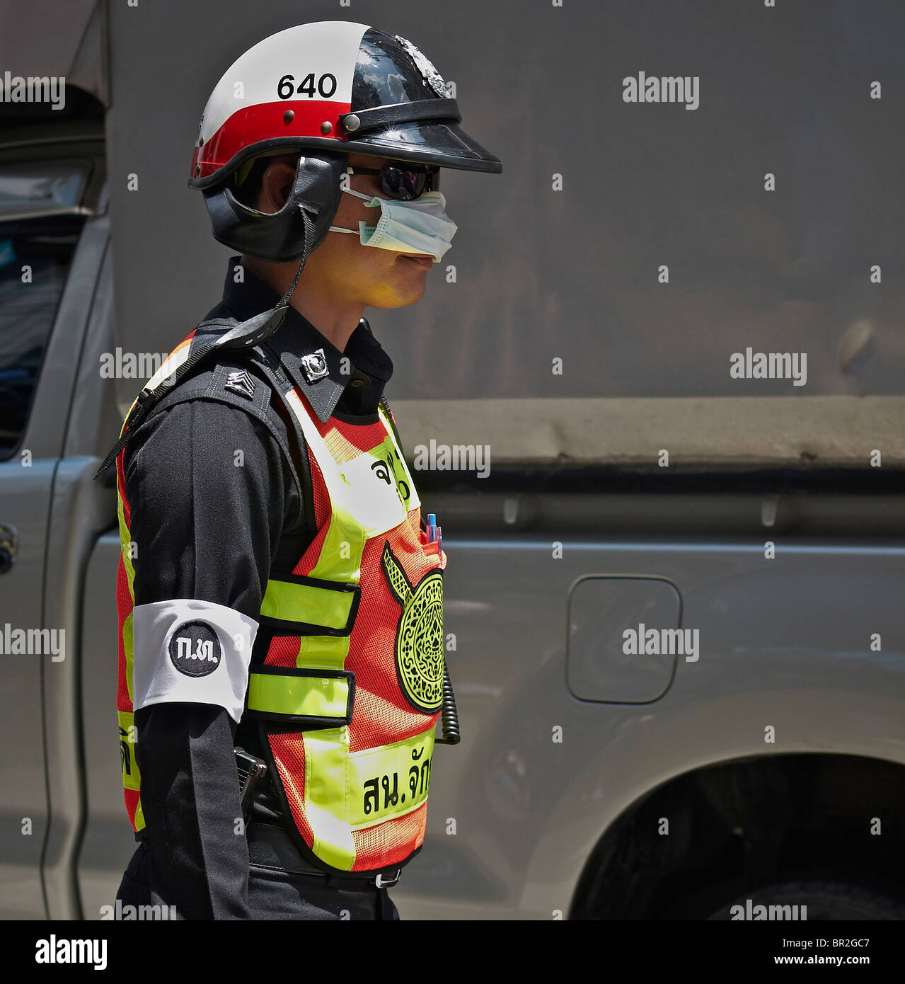 Thailand police officer wearing an anti pollution mask in Bangkok's high pollution traffic flow. S. E. Asia Stock Photo