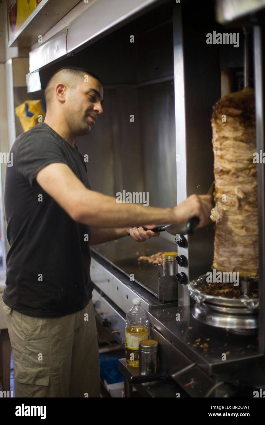 A man carves meat from a shawarma, King Shawarma Restaurant, Jerusalem