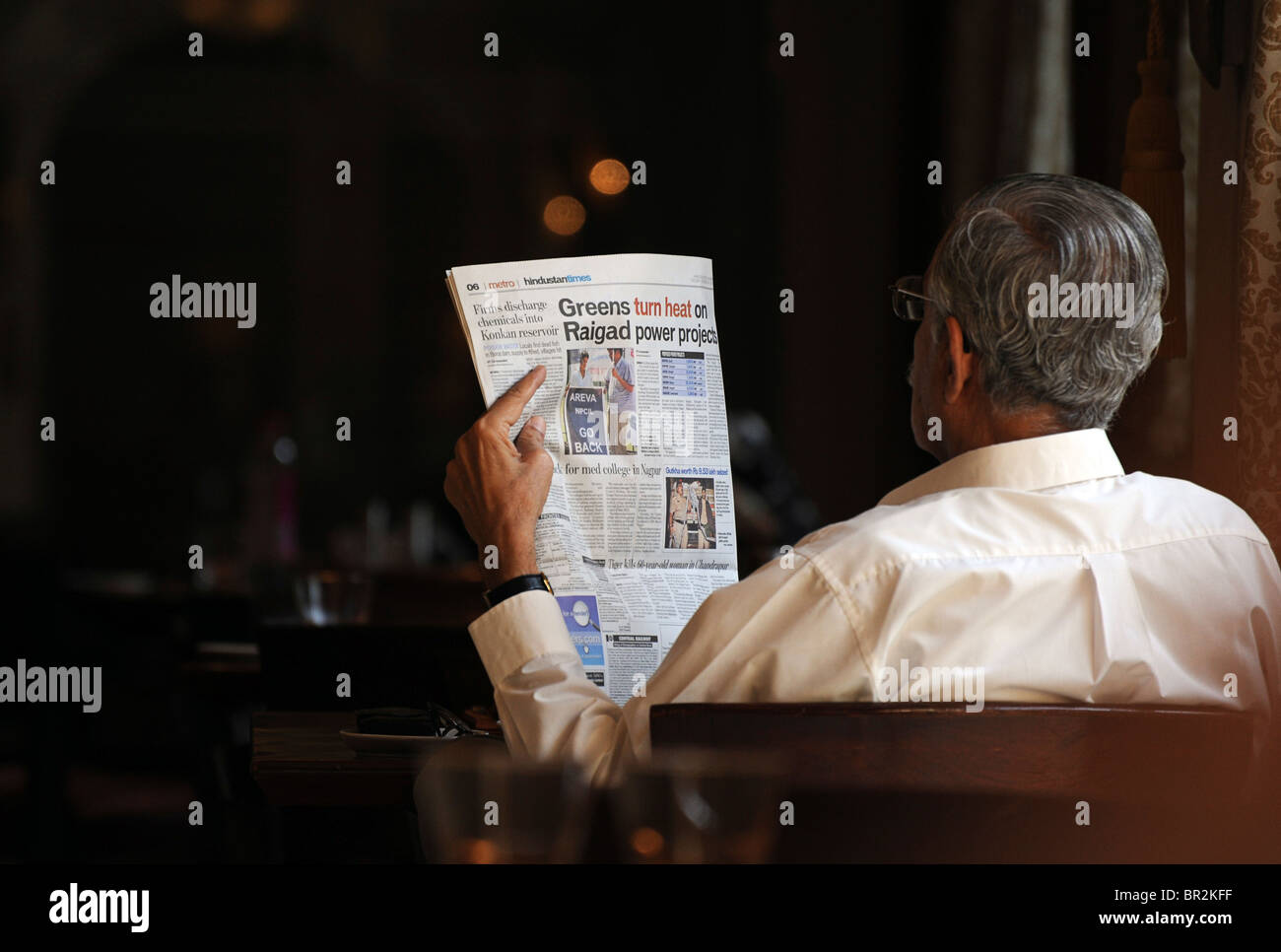 Educaed Indian man reading an English Language newspaper, Mumbai, India Stock Photo