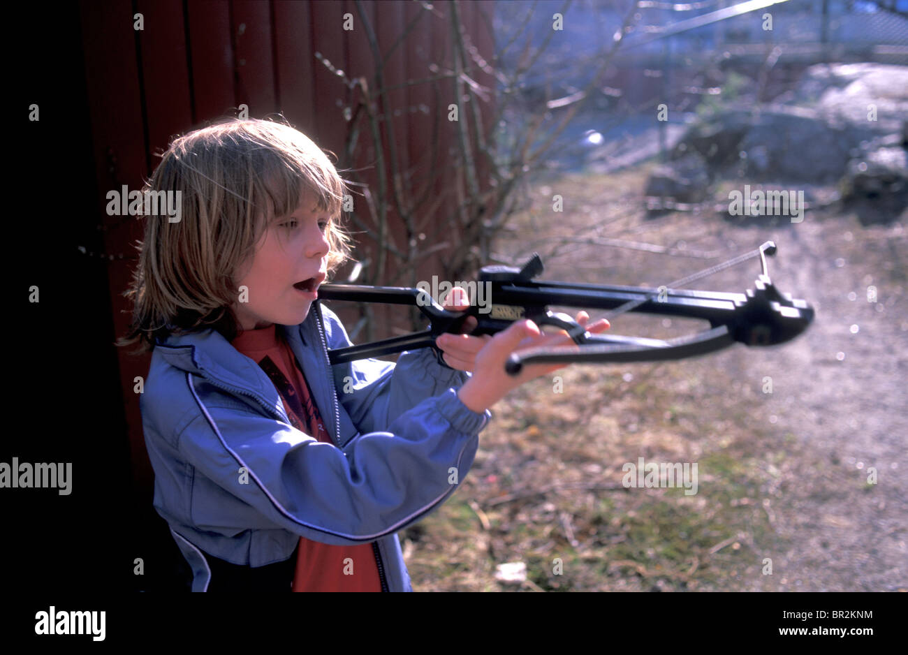 Kid playing with a cross bow Stock Photo