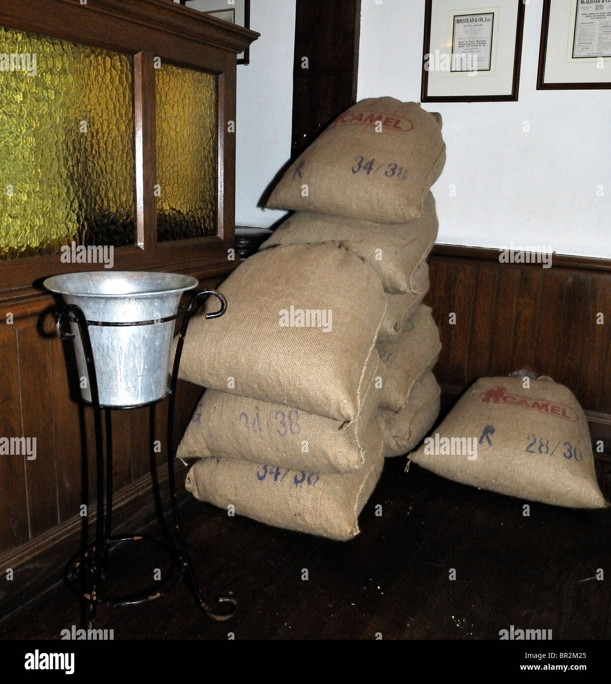 Sacks of peanuts piled in the Long Bat at Raffles Hotel, Singapore Stock Photo