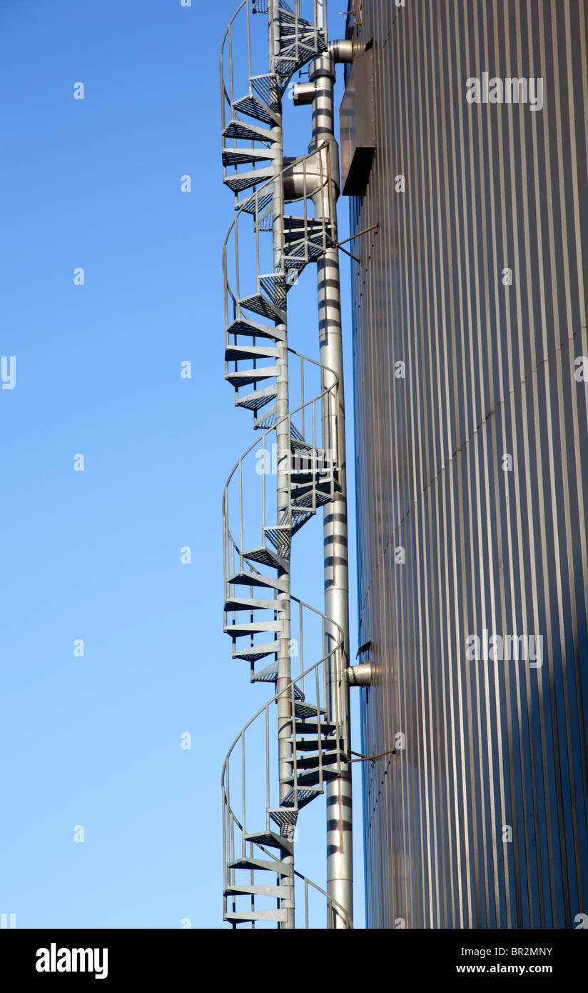 Outdoor spiral stairs attached to an oil tank wall , Finland Stock Photo
