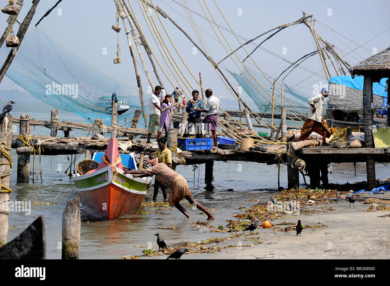 Coastal scene with fishing boat and jetty, Cochin, India Stock Photo
