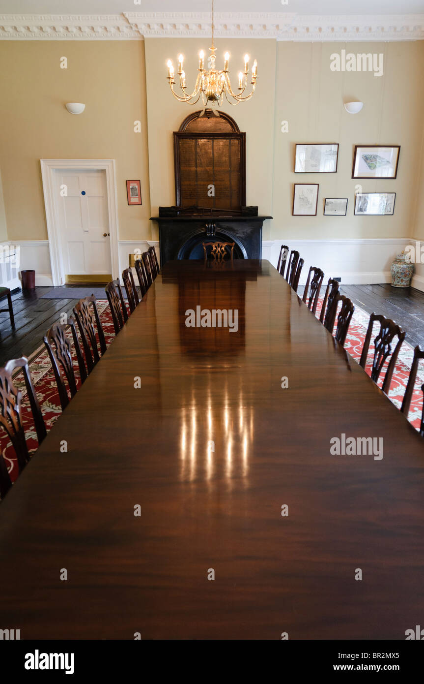 Long, old fashioned polished wooden dining table with chairs in a dining room Stock Photo